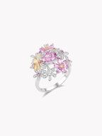 White gold pink sapphire ring with oval center, round pink halo, yellow side accents
