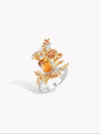 Cocktail ring side view with orange marquise stone and red-orange round halo stones