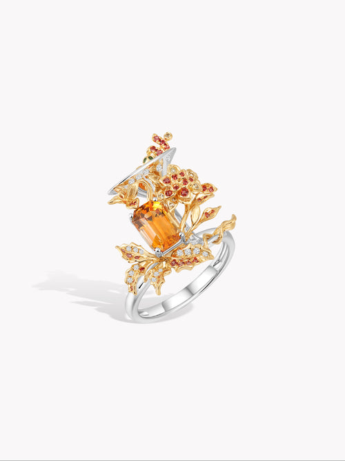 Cocktail ring side view with orange marquise stone and red-orange round halo stones
