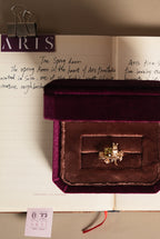 Gold cat guardian rose ring on cushion-cut gemstone with floral prongs, in jewelry box