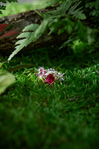 Silver ring with pink-red oval center stone and floral lily-of-valley side stones