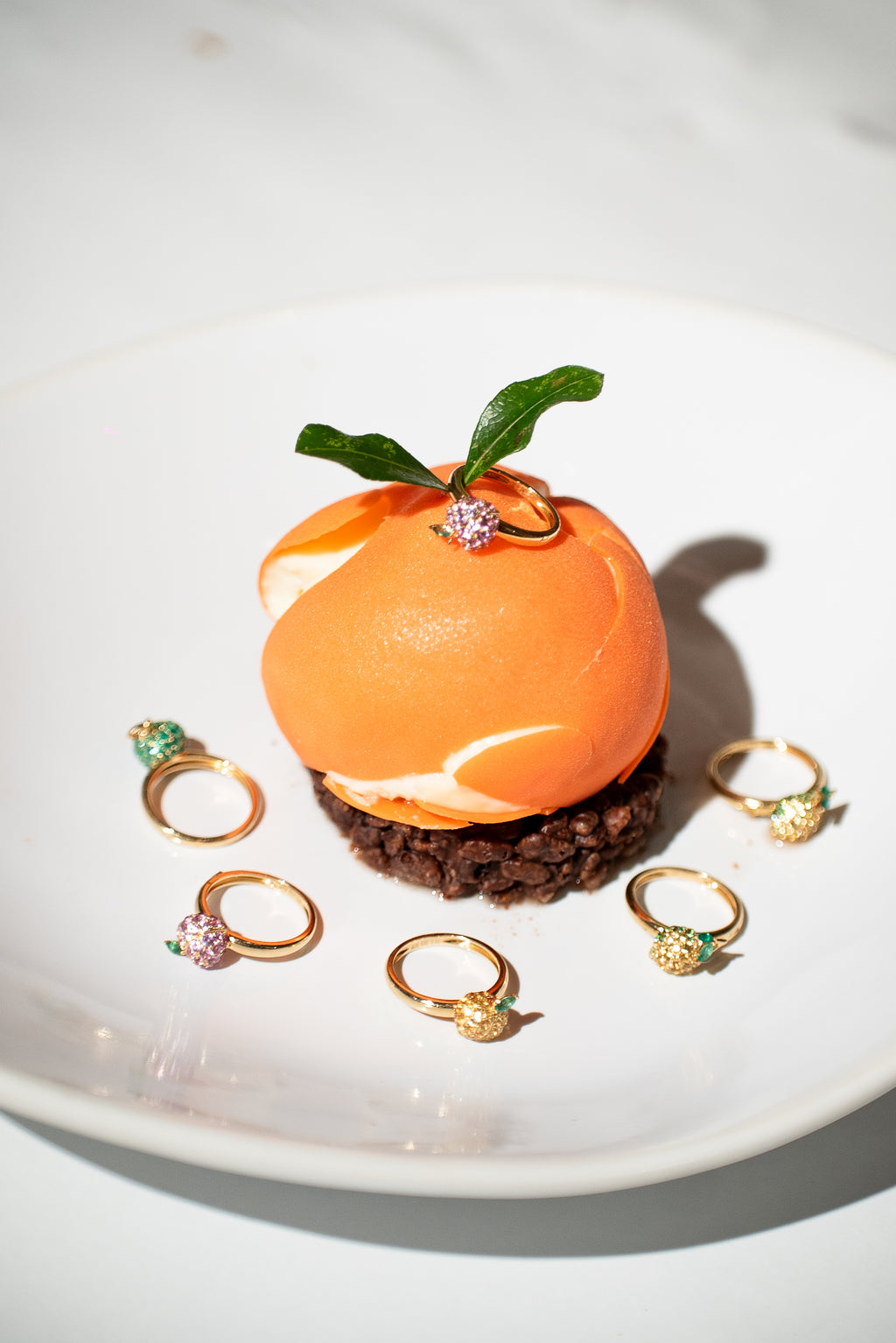 Gold-tone fruit charm rings, including orange fruit with green leaf and small stones