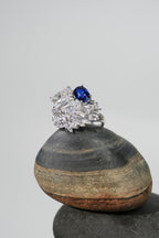 Swan wing diamond ring with oval blue sapphire at top, silver band