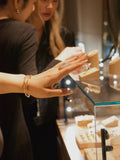 Jewelry display tray with hands arranging small earrings