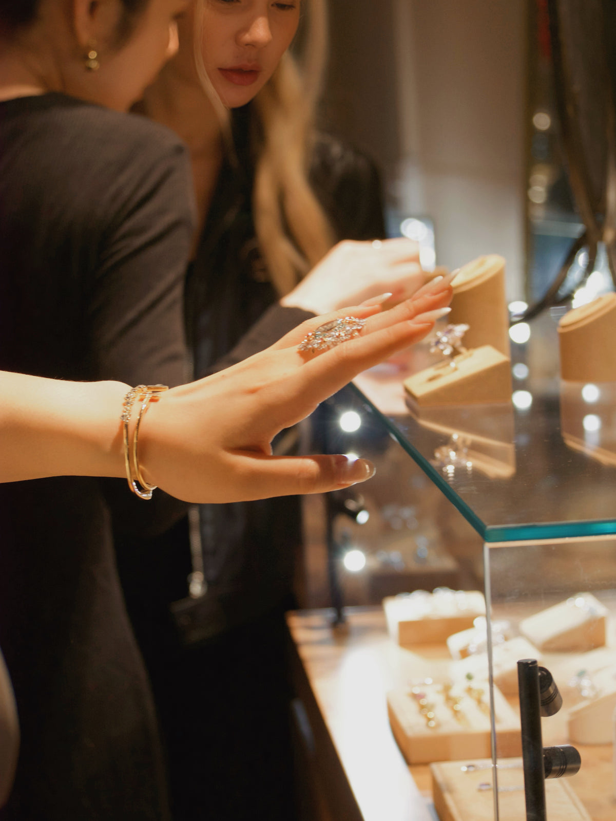 Jewelry display tray with hands arranging small earrings