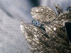 Swan sapphire ring side view with oval blue center stone and glittering pave wings