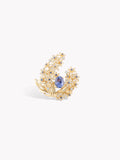 Gold-tone ring with blue sapphire center and diamond-like floral halo, angled front