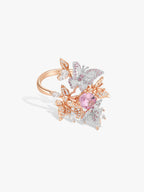 Butterfly wing ring with pink sapphire-like center stone, rose-gold band and white crystals