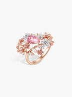 Rose-gold ring with pink oval center stone and flower halo with diamond accents