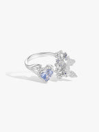 Open ring with heart-cut blue sapphire, white stone accents, and curved band