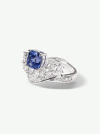 Sapphire blue square center ring with side diamond clusters on polished silver band