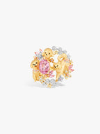 Gold-toned ring featuring two puppy figures, oval pink center stone, and diamond clusters.