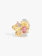 Gold-toned ring with pink oval gemstone in star setting, puppy motifs, and diamond halo.