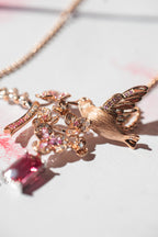 Rose-gold bird pendant with pink cherry blossom crystals and dangling pink gemstone