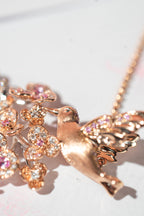 Rose-gold bird pendant with pink and clear crystal cherry blossom details on chain
