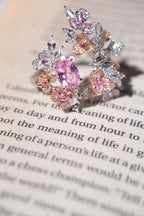 Close-up sterling silver ring with pink, orange and clear gemstones in floral cluster