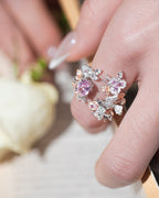 Sterling silver ring on finger with pink, orange and clear floral gemstone cluster